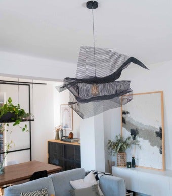 candeeiro de chapa metálica preto pendurado no teto de uma sala de estar